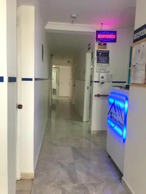 a hallway in a hospital with a neon sign on the wall at Casa Hotel Manco Mora in Medellín