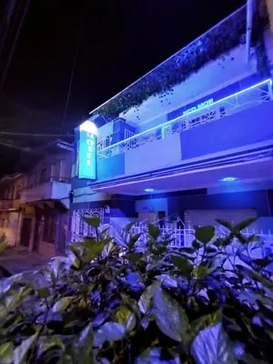 a building with a blue sign on it at night at Casa Hotel Manco Mora in Medellín