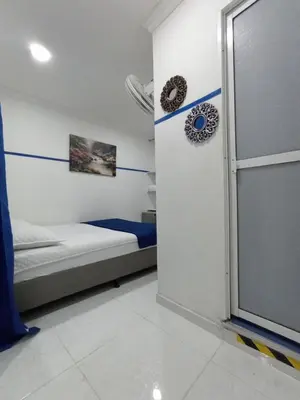 a bedroom with a bed and a door with a window at Casa Hotel Manco Mora in Medellín