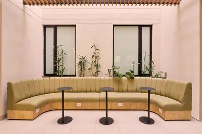 a bench in a room with two windows and plants at Hotel Lincoln in Medellín
