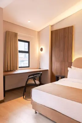 a hotel room with a bed and a desk at Hotel Lincoln in Medellín