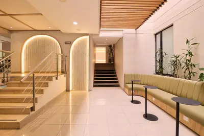 a lobby of a building with stairs and benches at Hotel Lincoln in Medellín