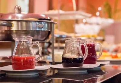 two glass mason jars on plates on a kitchen counter at Novelty Suites Hotel - Oviedo Mall in Medellín