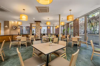 a restaurant with tables and chairs and windows at Affinity ApartaHotel - Extended Stay in Medellín