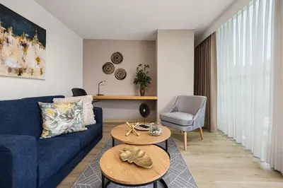 a living room with a blue couch and a table at Affinity ApartaHotel - Extended Stay in Medellín