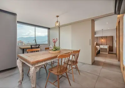 a dining room with a wooden table and chairs at Affinity ApartaHotel - Extended Stay in Medellín