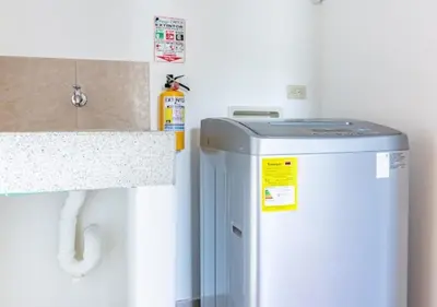 a small refrigerator in a kitchen next to a counter at Affinity ApartaHotel - Extended Stay in Medellín