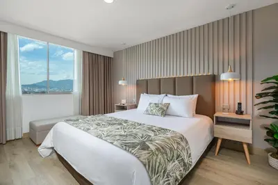 a bedroom with a large bed and a large window at Affinity ApartaHotel - Extended Stay in Medellín