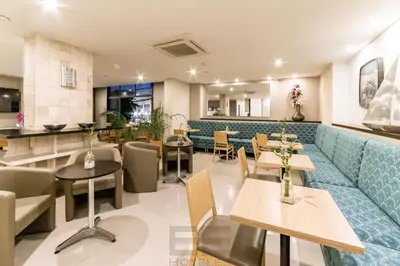 a restaurant with a blue couch and tables at Leblon Suites Hotel Milla de Oro in Medellín