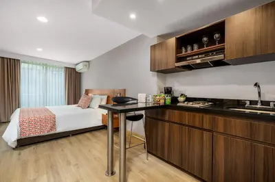 a hotel room with a bed and a kitchen at Leblon Suites Hotel Milla de Oro in Medellín