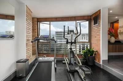 a gym with two treadmills and a treadmill at Leblon Suites Hotel Milla de Oro in Medellín