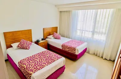 a hotel room with two beds and a window at Portal del Rodeo ApartaHotel - Arkadia Mall in Medellín