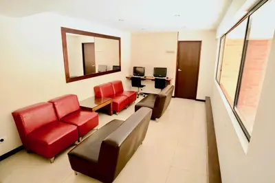 a living room with red furniture and a mirror at Portal del Rodeo ApartaHotel - Arkadia Mall in Medellín