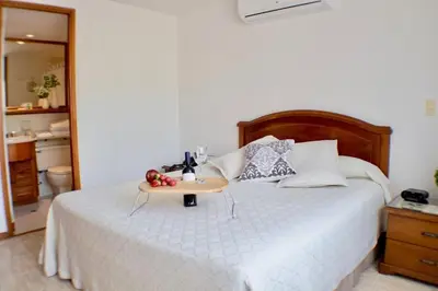 a bedroom with a bed with a tray of fruit on it at Portal del Rodeo ApartaHotel - Arkadia Mall in Medellín