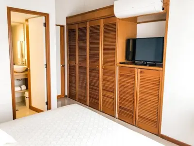 a bedroom with a bed and a tv and a closet at Portal del Rodeo ApartaHotel - Arkadia Mall in Medellín
