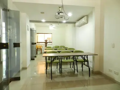 a group of tables and chairs in a room at Hotel Palma 70 in Medellín