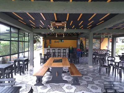 a wooden table in a restaurant with tables and chairs at Finca Campestre Villa del Campo in Santa Rosa de Cabal
