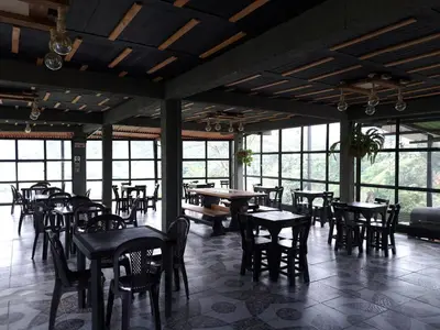 a dining room with tables and chairs and windows at Finca Campestre Villa del Campo in Santa Rosa de Cabal