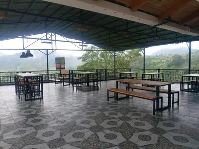 a restaurant with tables and chairs with mountains in the background at Finca Campestre Villa del Campo in Santa Rosa de Cabal