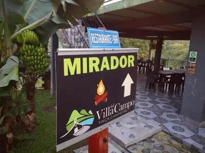 a sign for a white camp with a fire at Finca Campestre Villa del Campo in Santa Rosa de Cabal