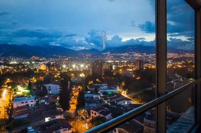 a view of a city at night from a window at Sites Hotel in Medellín