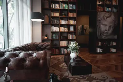 a living room with a leather couch and book shelves at Sites Hotel in Medellín