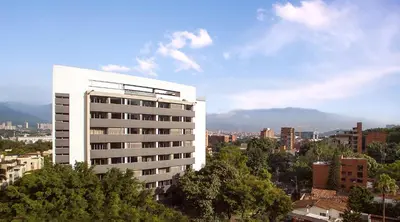 a tall white building in a city with trees at Sites Hotel in Medellín