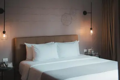 a bedroom with a large bed with white pillows at Sites Hotel in Medellín