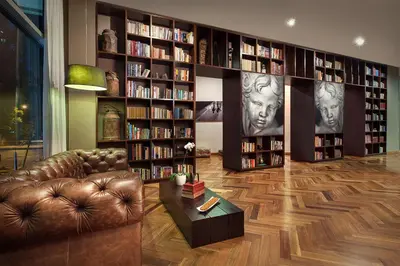 a living room with a couch and book shelves with books at Sites Hotel in Medellín