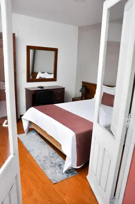 a bedroom with a bed with a mirror and a desk at Ayenda Escorial 1936 in Manizales