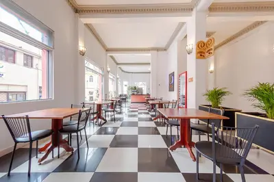 a row of tables and chairs in a restaurant at Ayenda Escorial 1936 in Manizales