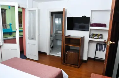 a bedroom with a bed and a television in a room at Ayenda Escorial 1936 in Manizales