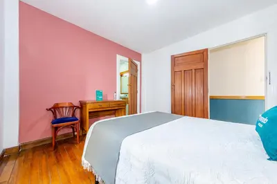 a bedroom with a bed and a desk and a table at Ayenda Escorial 1936 in Manizales