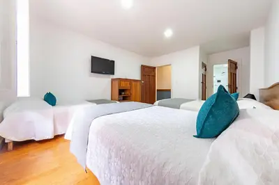 a bedroom with two beds with blue pillows on them at Ayenda Escorial 1936 in Manizales