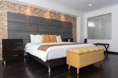 a bedroom with a large bed with a large headboard at Hotel Varuna in Manizales
