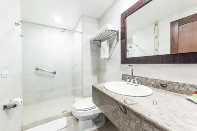 a bathroom with a sink and a toilet and a shower at Hotel Varuna in Manizales
