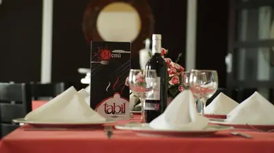 a table with a bottle of wine and glasses on it at Hotel Varuna in Manizales