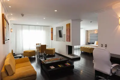 a living room with a couch and a bed at Hotel Varuna in Manizales