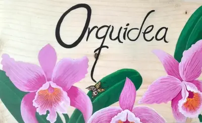 a picture of pink orchid flowers and a sign that reads orderula at 40 Amigos Hotel in Jardin