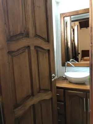 a bathroom with a wooden door and a sink at 40 Amigos Hotel in Jardin