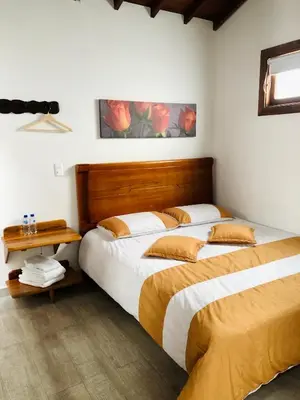 a bedroom with two beds and a wooden headboard at 40 Amigos Hotel in Jardin