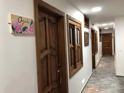 a hallway with a row of wooden doors in a room at 40 Amigos Hotel in Jardin