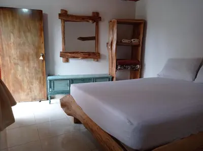 a bedroom with a white bed and a blue table at Alojamiento Rural Altos del Molino in Los Andes