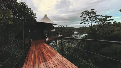 a wooden walkway with a bridge over a river at Bosko in Guatapé