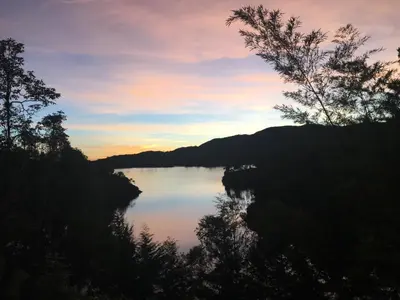 a view of a lake at sunset at Ecolodge Bahia del Peñón in Guatapé