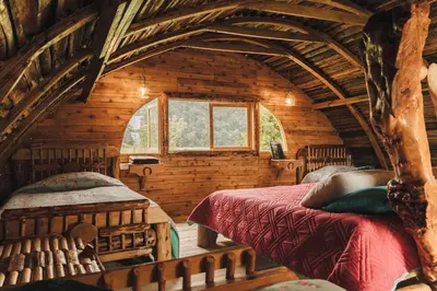 a bedroom with two beds in a log cabin at Hostal La Laguna in Villamaría