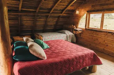 a bedroom with a bed in a log cabin at Hostal La Laguna in Villamaría