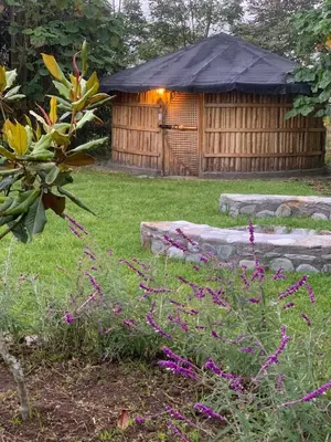 a gazebo in a garden with purple flowers at Hostal La Laguna in Villamaría