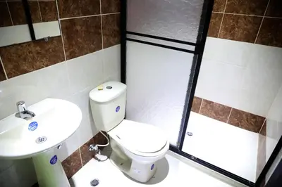 a bathroom with a toilet and a sink and a shower at Hospedaje Aquel Almendro in Santa Fe de Antioquia
