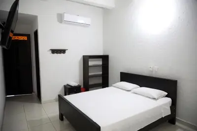 a bedroom with a bed in a white room at Hospedaje Aquel Almendro in Santa Fe de Antioquia